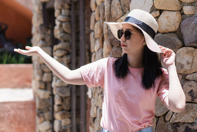 Young woman wearing hat while standing outdoors