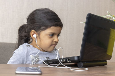 Girl using laptop on table at home