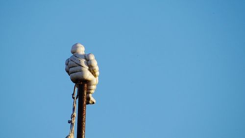 Low angle view of statue against clear blue sky