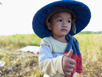 Close-up of boy wearing hat standing on field