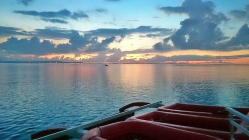 Boats in sea at sunset