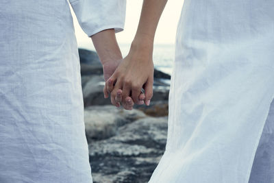 Girls holding hands wearing white fabric