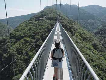 Rear view of woman on footbridge