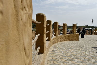 View of wooden posts on street against sky