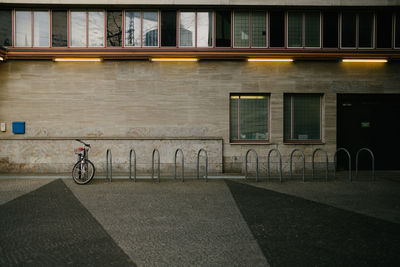 Man riding bicycle on road against building