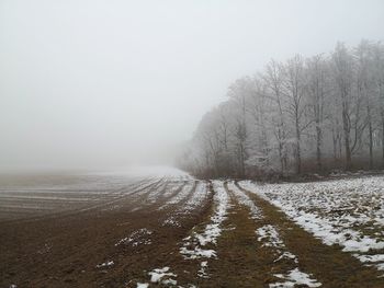 Scenic view of snow covered land against sky