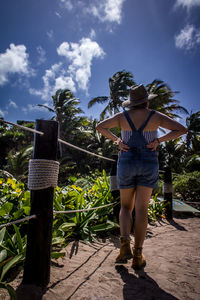 Rear view of woman standing against trees