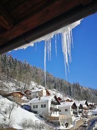 Houses on snow covered landscape against sky