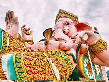Low angle view of ganesha statue against sky