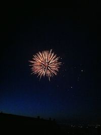 Fireworks display over a mountain at night