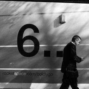 Side view of man standing against wall