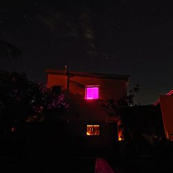 Low angle view of illuminated building against sky at night