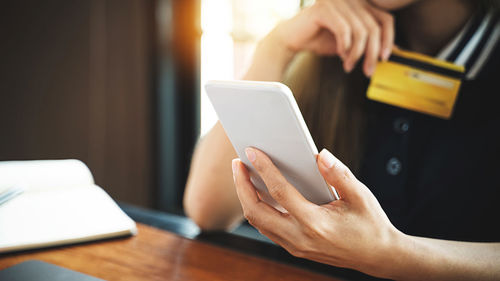 Midsection of man using mobile phone