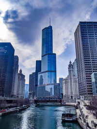 Modern buildings in city against cloudy sky