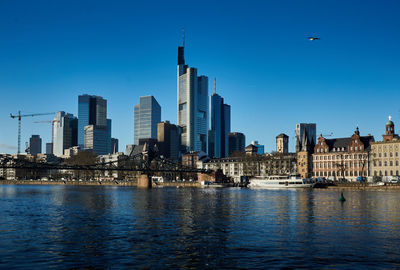 Bridge over river main with city buildings in background