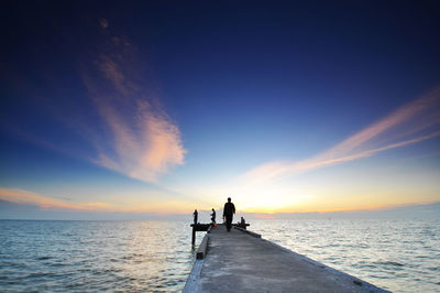 Silhouette of person in sea at sunset