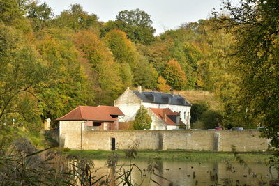 Built structure by trees and house in forest