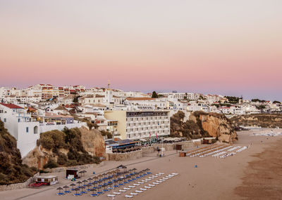 High angle view of townscape by beach against sky during sunset