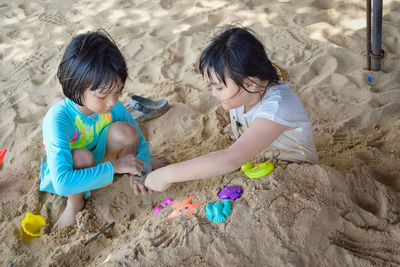 High angle view of girls playing with toys at beach