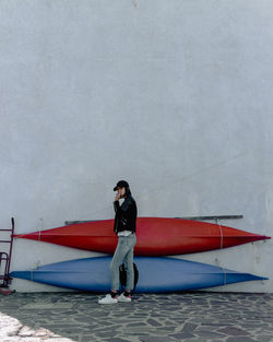 Portrait of young woman standing on boat against sky