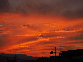 Silhouette mountain against dramatic sky during sunset