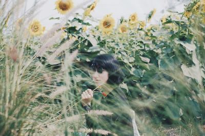 Young woman amidst plants in field