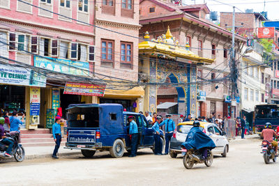 People on road against buildings in city