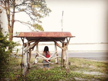 Woman sitting on bench in park