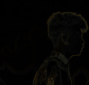 Side view of man statue against black background