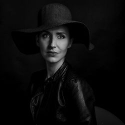 Portrait of man wearing hat against black background