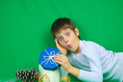 Portrait of boy against green background