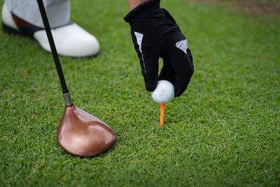 Low section of person playing with ball on grass