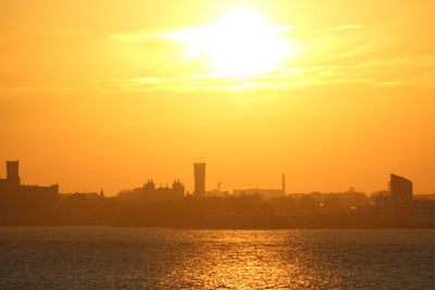 Scenic view of silhouette buildings against sky during sunset