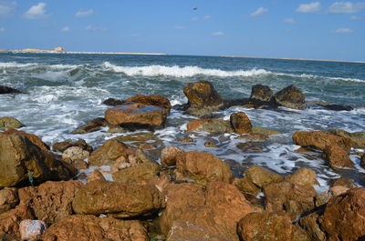 Rocks on beach against sky