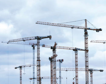 Low angle view of cranes against sky