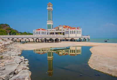 Built structure on beach against blue sky