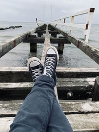 Feet high up on vintage wooden pier at baltic sea