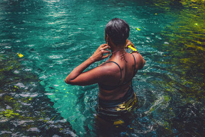 Rear view of woman swimming in a river