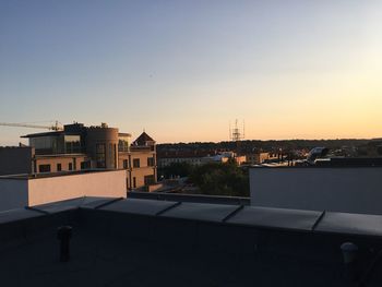 Buildings in city against clear sky at sunset