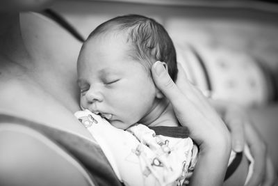 Close-up high angle view of mother carrying cute baby boy at home