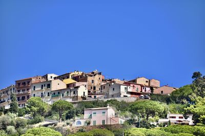 Buildings in city against clear blue sky