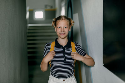 Portrait of young man standing against wall