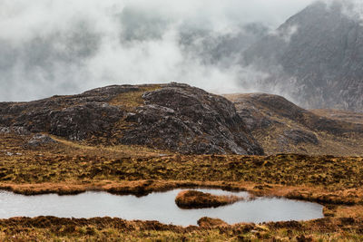 Scenic view of lake by mountain against sky