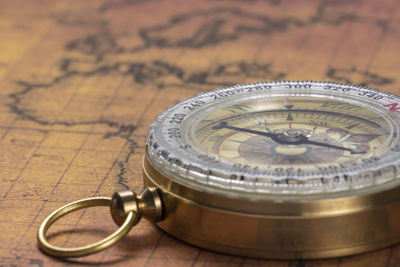Close-up of navigational compass on old map