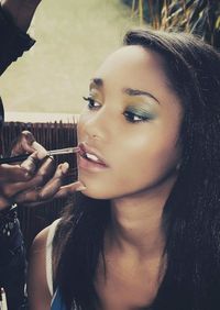 Close-up portrait of beautiful woman holding camera