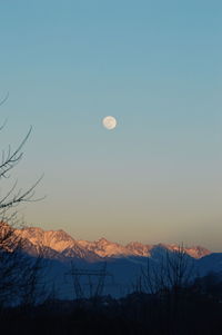 Full moon over mountain at dusk