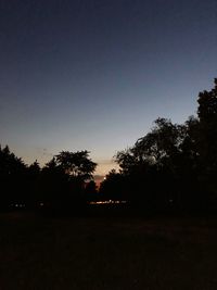 Silhouette trees on field against sky during sunset