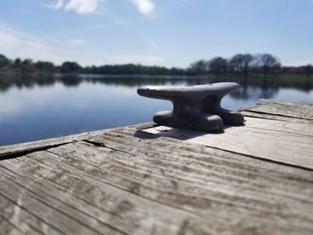 Close-up of wooden pier on lake against sky