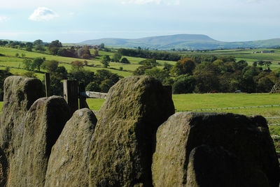 Scenic view of old stone wall and countryside against sky