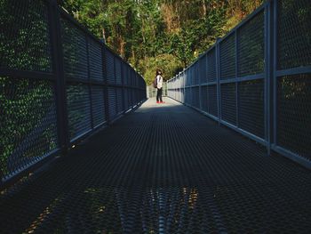 Portrait of woman standing on footbridge